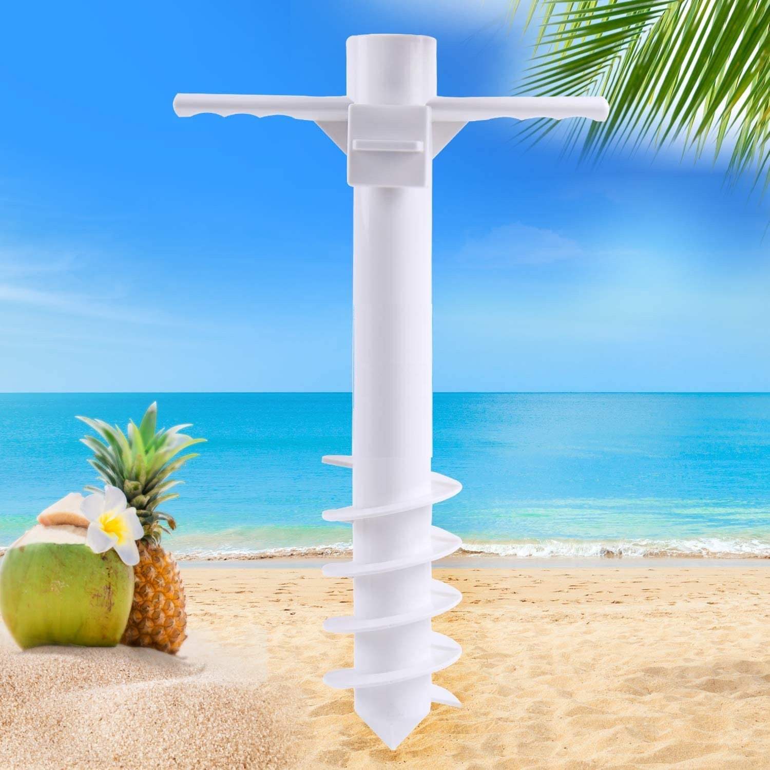 Beach umbrella sand anchor on a beach with a pineapple and coconut in the foreground.
