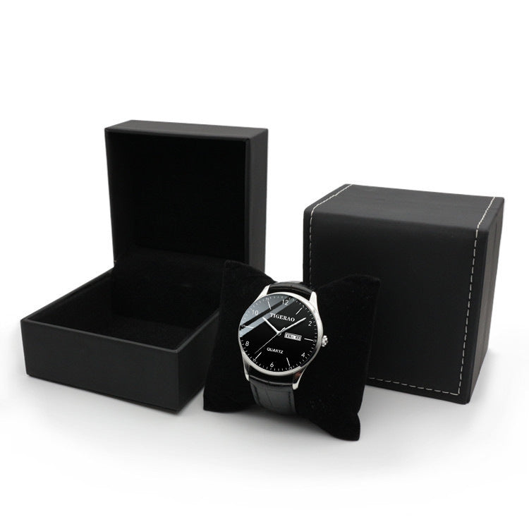 Black wristwatch in an open black box on a white background.