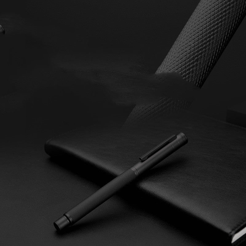 Black pen and notebook on a dark surface.