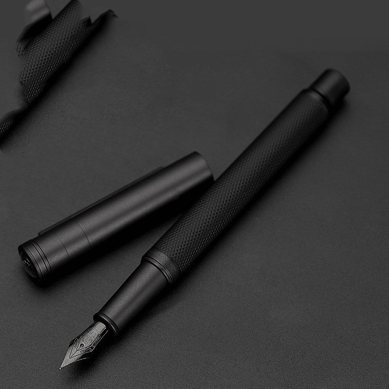 Black fountain pen on a dark surface.
