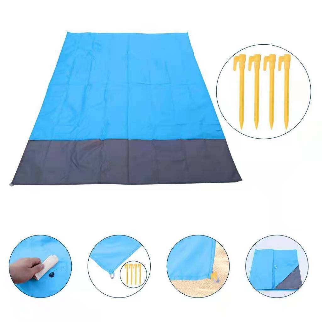 Blue and gray foldable beach mat with sand anchor illustration on a white background.