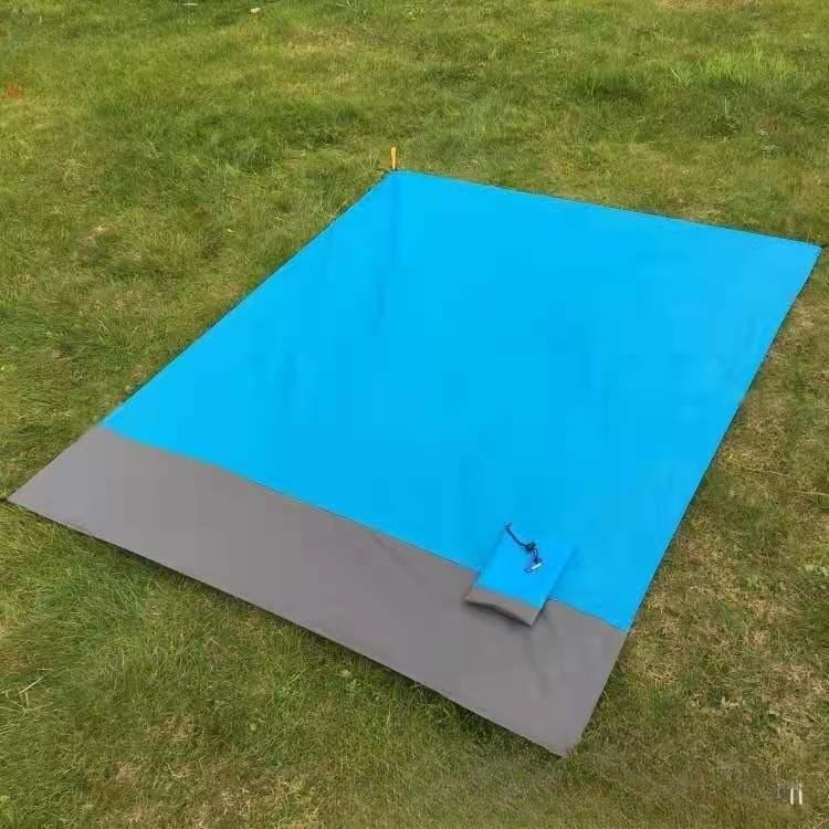 Sapphire blue and gray foldable beach mat on grass.