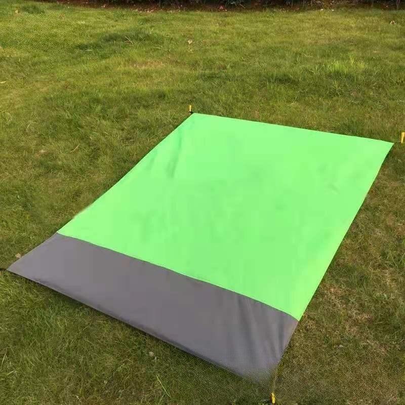 Fruit green and gray foldable beach mat on grass.