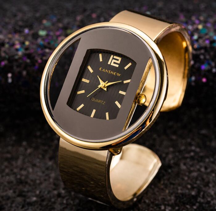 Women´s gold bracelet watch with «CANSNOW» branding on dark textured background.