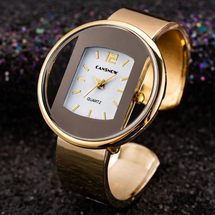 Gold women´s bracelet wristwatch on dark background.