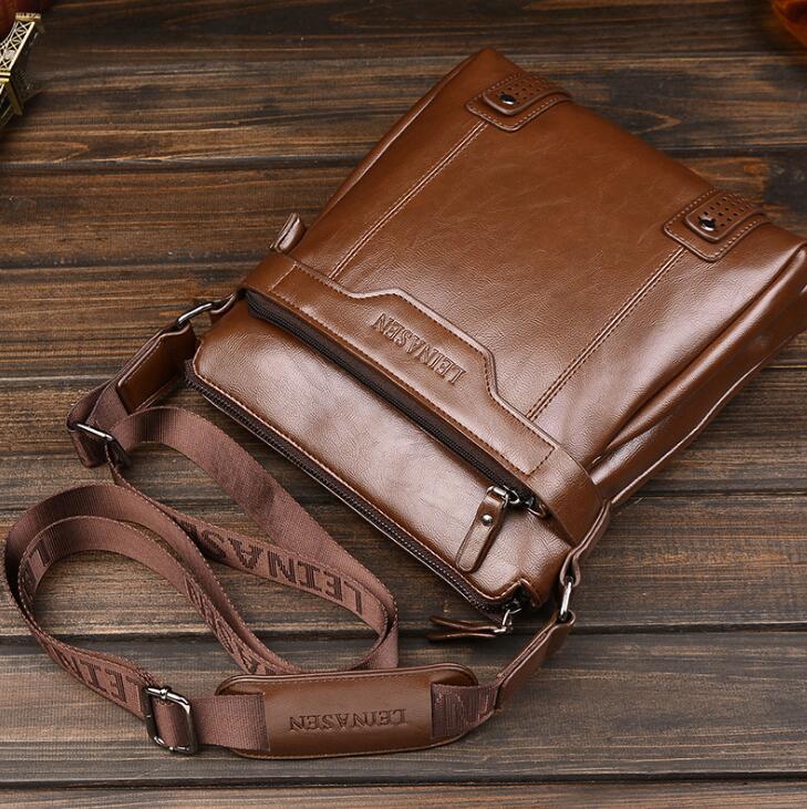 Khaki leather crossbody bag on a wooden surface.