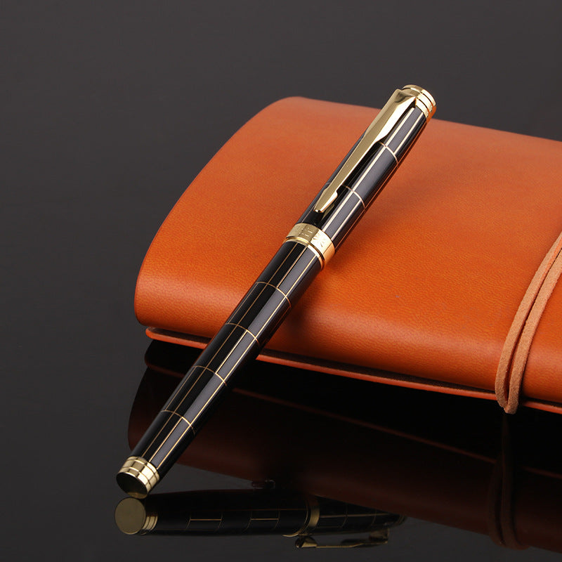 Luxury pen with gold accents on a brown leather notebook.