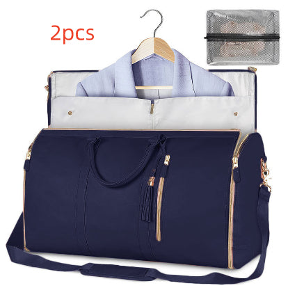 Navy blue travel bag with a shirt, white pants, and a mesh pouch on a white background.