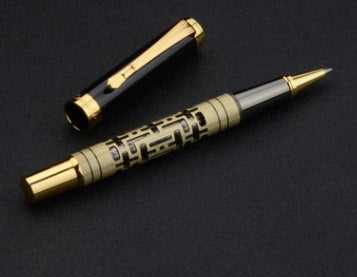 Pen with gold accents on a black background.