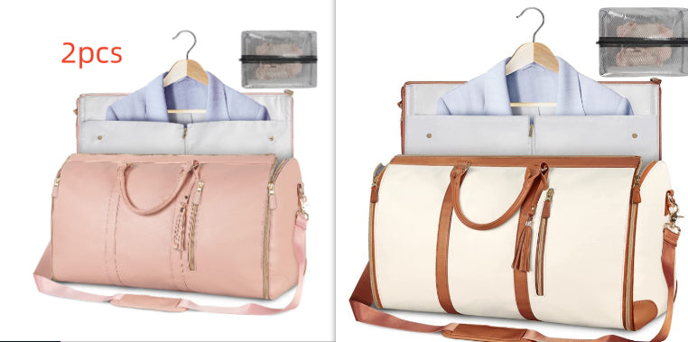 Pink and beige travel bags with hangers and clothes on a white background.