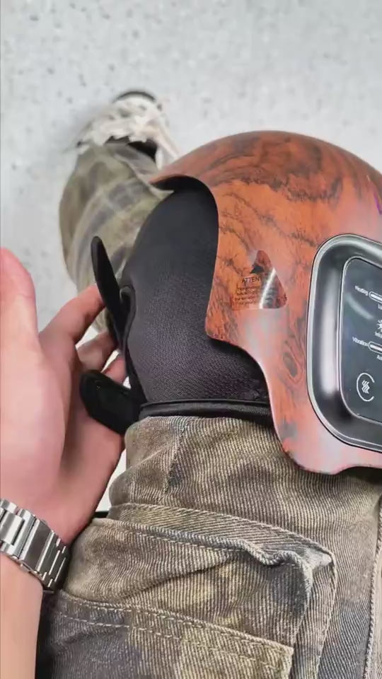 Wood-grain electric knee massager worn on a woman’s knee, demonstrating pain relief use after knee injury, showing heat, massage, and therapy features designed to reduce discomfort and support knee recovery at home.