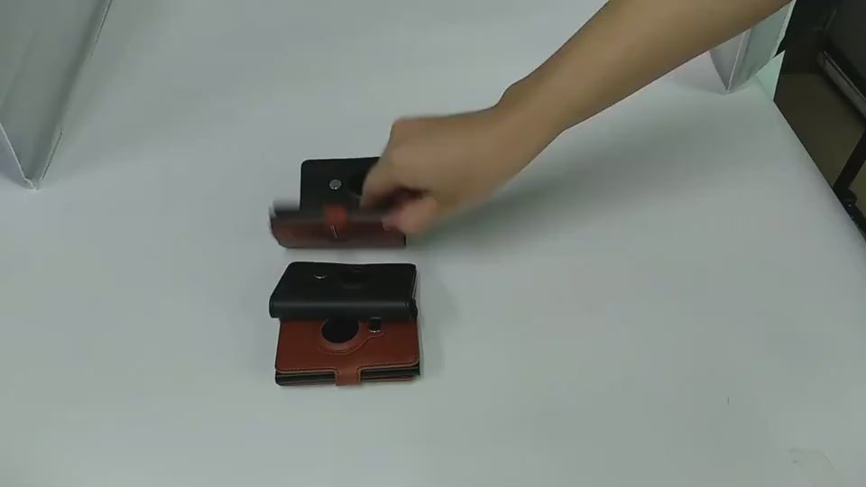 Hands demonstration an empty cardholder with three addtional cardholders on a table.