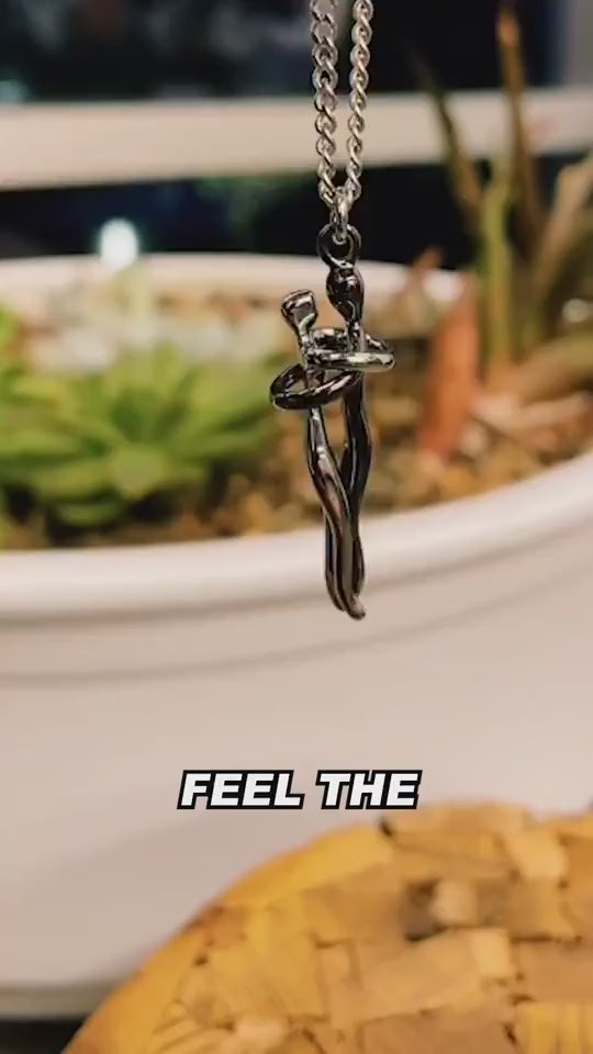 Lovers hug pendant necklace shown in a greeting card, held in different hands, worn on a woman’s neck, and displayed in multiple design variations on a table, presenting a unisex hug necklace as a symbolic gift of love, connection, and affection.