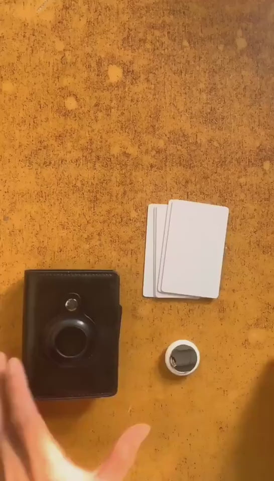 Single brown leather cardholder being demonstrated by two hands, inserting a key fob and cards, then opening to show the interior.