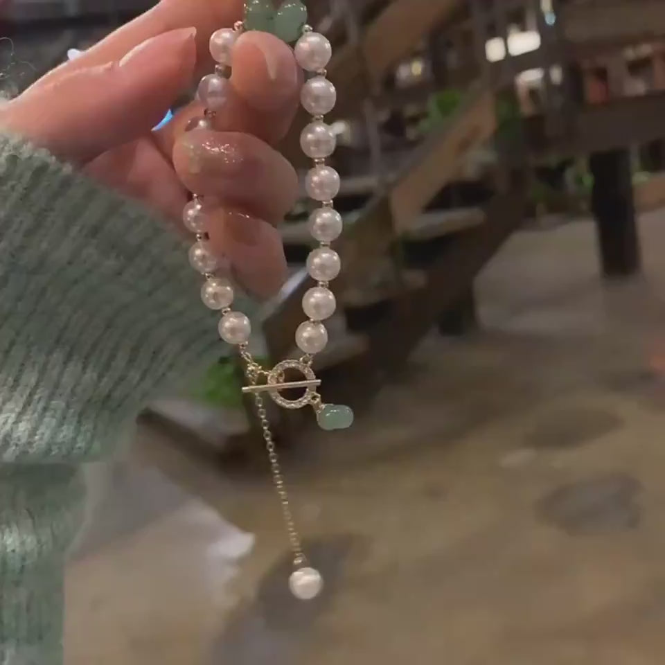 Video showing a woman holding a women´s beaded necklace in her hand, then opening her palm to display the pink gemstone beads and silver cross pendant in detail.