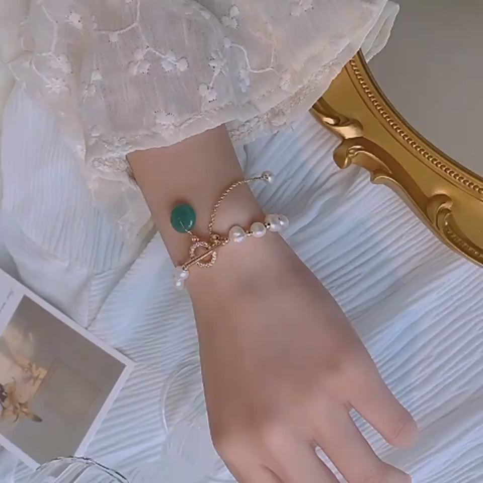 Video showing a women turning a necklace around her wrist to display it to the camera.