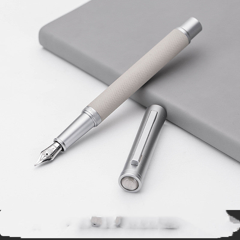 Silver fountain pen with cap on a white surface.