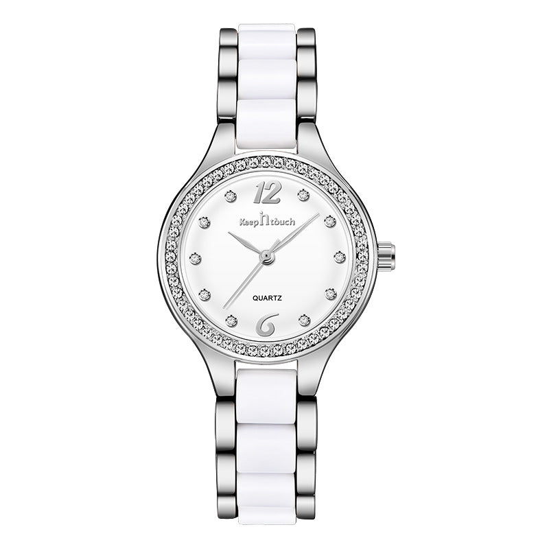 Silver and white dial women´s watch with diamond-like accents on white background.