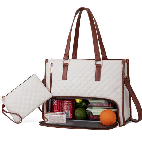 White quilted diaper bag with brown straps containing snacks and fruits on a white background.