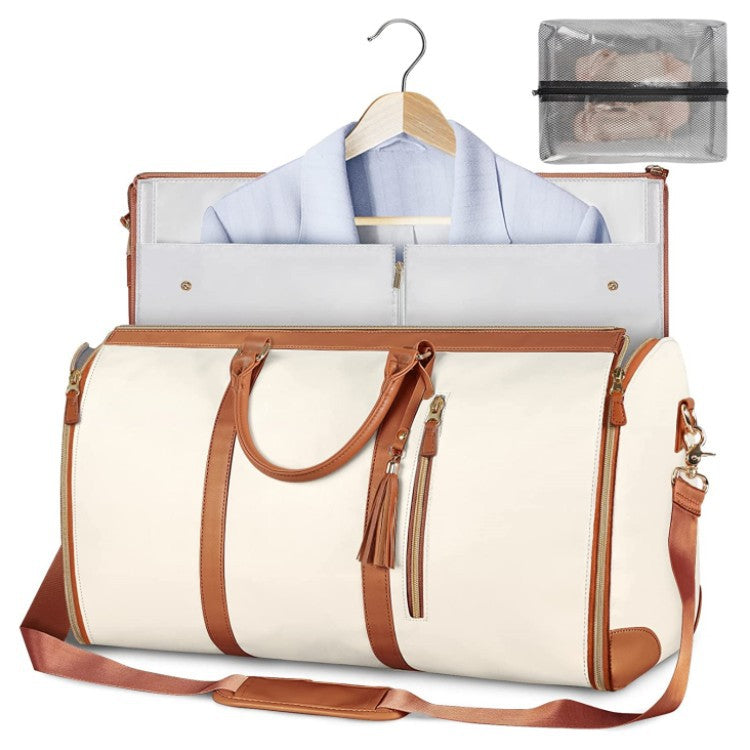 White travel bag with brown straps and a shirt on a hanger, with a clear pouch in the background.