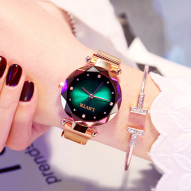 Women´s rose gold watch with green dial and bracelet under bright light.