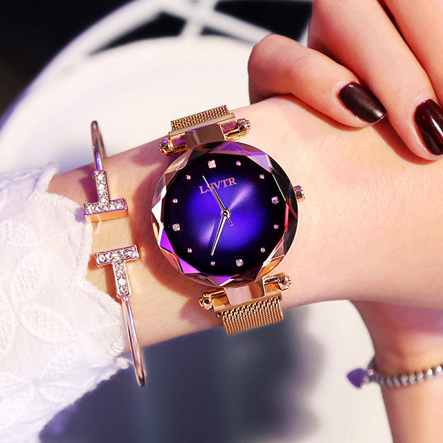 Women´s rose gold watch with purple dial and bracelet under bright light.