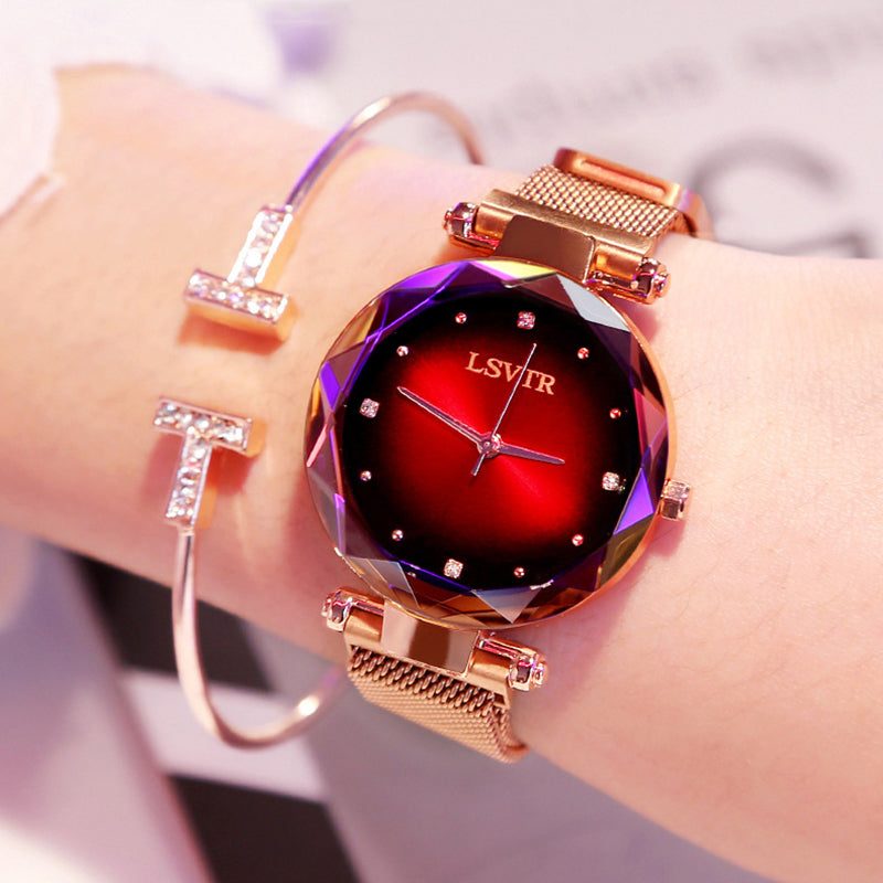 Women´s rose gold watch with red dial, purple geometric bezel and bracelet under bright light.